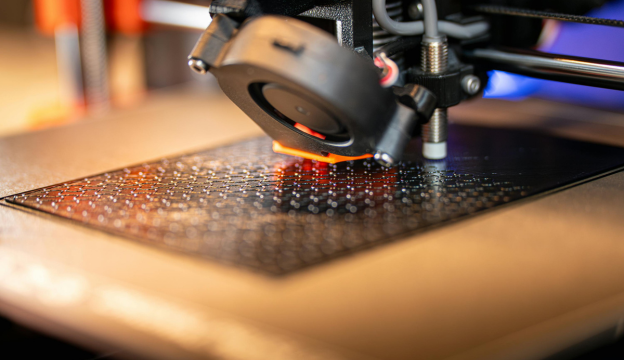 un gros plan sur la base d'un objet en cours de fabrication par une imprimante 3D. FDM